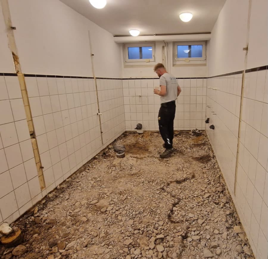 Maxim Matis bei Rückbauarbeiten in einem entkernten Badezimmer